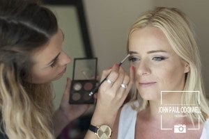 This is a picture of a Bride having make up done on her wedding day