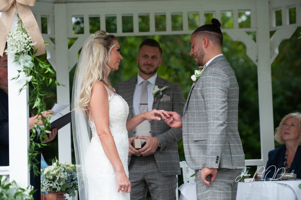 bride and groom exchanging rings at Sheene Mill